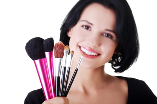 Young make-up artist woman holding brushes