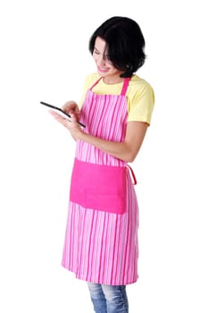 Young woman in pink apron using tablet computer, isolated
