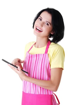 Young woman in pink apron using tablet computer, isolated
