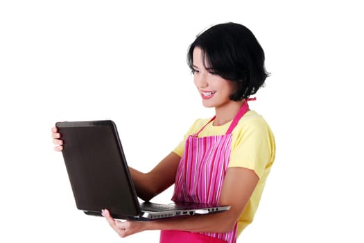 Modern housewife or female worker with laptop wearing pink apron