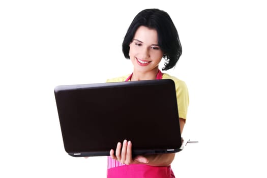 Modern housewife or female worker with laptop wearing pink apron