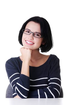 Smiling student girl sitting at the desk, isolated on white