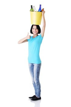 Young woman carrying a bin full of empty recyclable glass bottles. Recycling concept