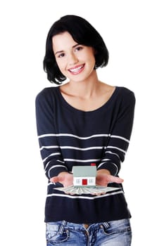 Beautiful young woman holding US dollars bills and house model over white - real estate loan concept