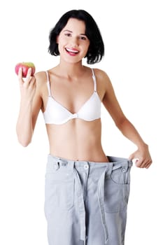 Young woman showing how much weight did she lost. Isolated on white