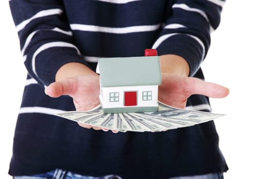 Woman holding US dollars bills and house model over white - real estate loan concept