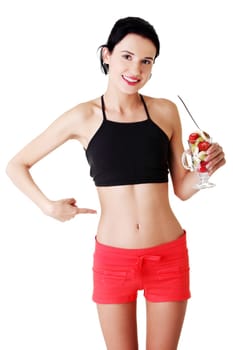 Pretty fit woman eating fruit salad , isolated on white