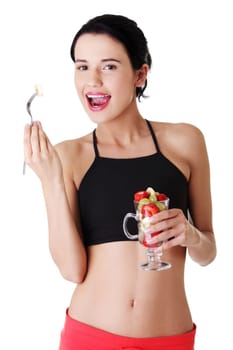 Pretty fit woman eating fruit salad , isolated on white