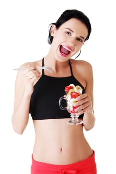 Pretty fit woman eating fruit salad , isolated on white