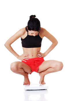Portrait of a happy woman on scales. Weight-loss concept.