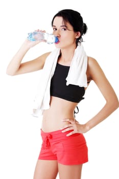Young fit woman drinking mineral water after fitness exercise