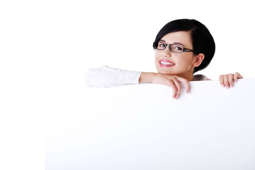 Smiling young business woman showing blank signboard, over white background isolated