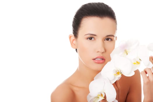 Portrait of beautiful young woman with health skin and with orchid flower