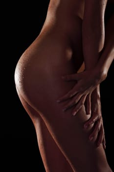 Sexy wet body of slim woman, over black background