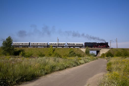 Old retro steam train passing through polish countryside