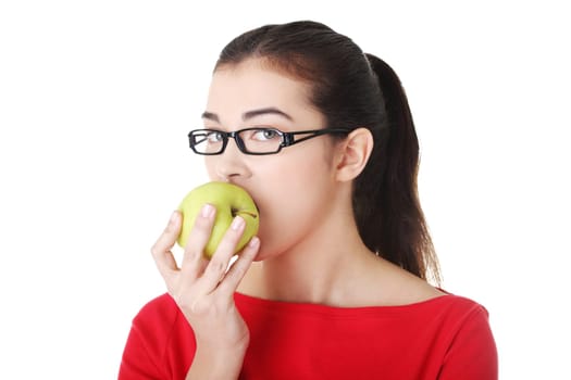 Attractive young woman eating green apple. Isolated