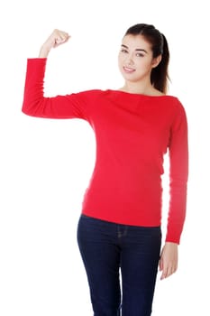 Young woman shows her biceps. She wears glasses and informal dress. Isolated on the white background.