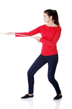 Casual woman pulling a rope, isolated on white