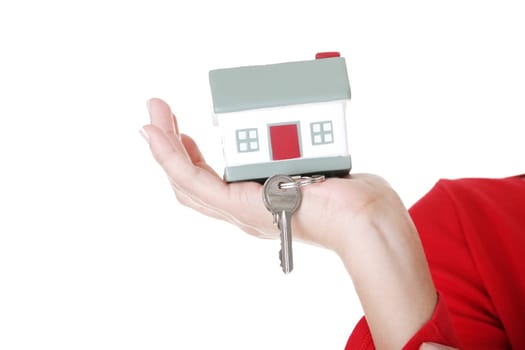 Hand holding a house key. Isolated on white background.