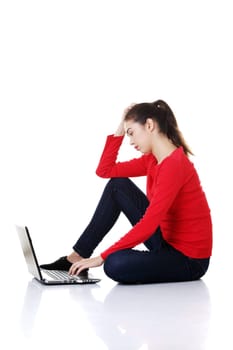 Sad woman looking on laptop screen. Isolated on white.