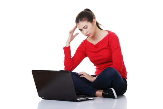 Sad woman looking on laptop screen. Isolated on white.