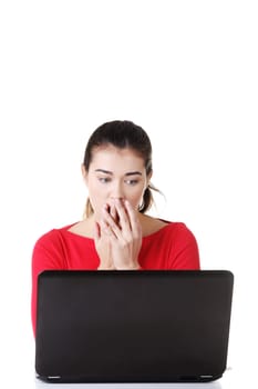Surprised and disgusted woman working on laptop. Isolated on white.