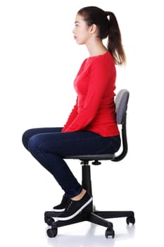 Young happy woman sitting on a wheel chair, isolated over a white background