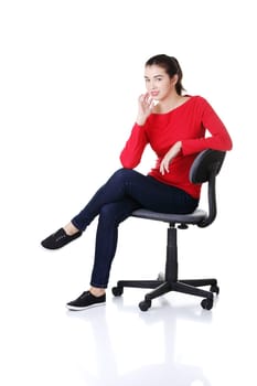 Young happy student woman or businesswoman sitting on a wheel chair, isolated over a white background