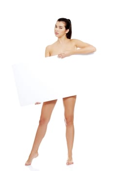 Sexy naked brunette holding empty board , isolated on white.