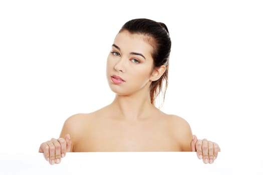 Sexy naked brunette holding empty board , isolated on white.