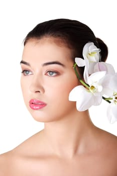 Portrait of beautiful young woman with health skin and with orchid flower