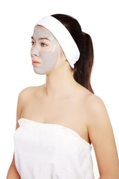 Beautiful woman with clay facial mask, isolated on white