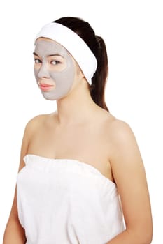 Beautiful woman with clay facial mask, isolated on white