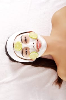 Attractive young woman with fruit mask on a face at spa saloon
