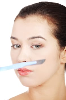 Cosmetic surgery concept. Female face in background of scalpel.