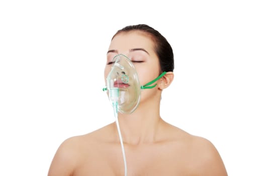 Diseased female patient wearing a oxygen mask against white background