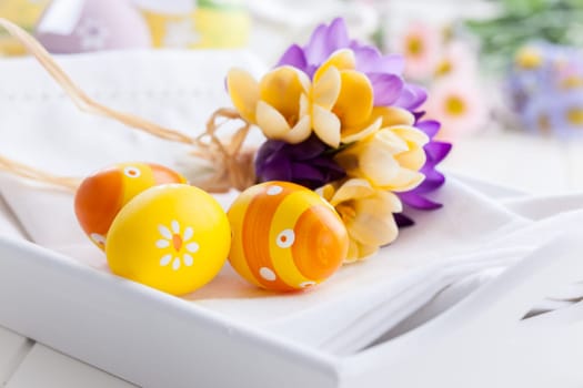 Easter eggs with spring flowers decorating table