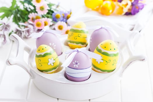 Easter eggs with spring flowers decorating table