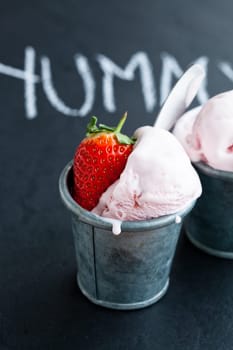 Closeup of strawberry ice cream and strawberry with chalk written word on dark background