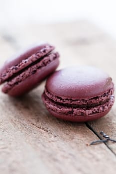 Closeup of two chocolate macaroons on wooden table