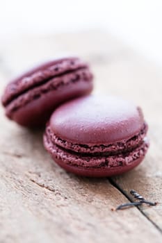 Closeup of two chocolate macaroons on wooden table