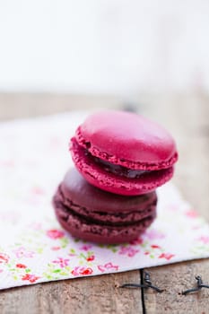 Closeup of two macaroons resting on serviette on wooden table