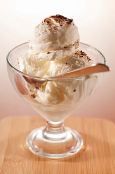 Fresh vanilla ice cream in tall glass close up