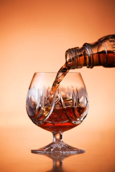 Close up of pouring cognac into glass