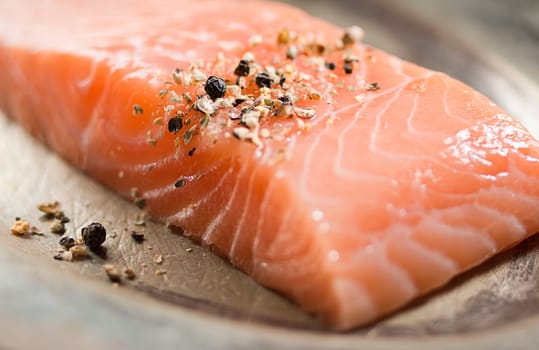 Raw salmon fillet on a plate close up