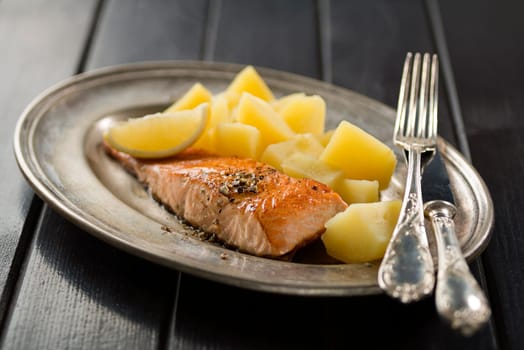 Baked salmon fillet with boiled potatoes close up