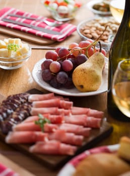 Pear and grapes in focus on table full of food