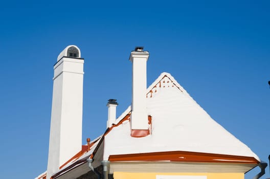 Chimneys and roof brought by a snow, a close up