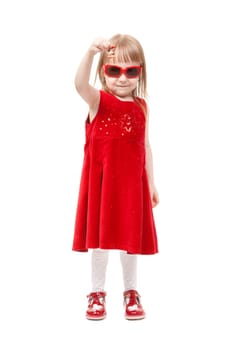 Charming girl in red dress and sunglasses show delicious candy. In the studio, isolated on white background