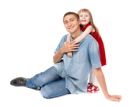 Smiling father and young daughter sitting on the floor. Isolated on white background